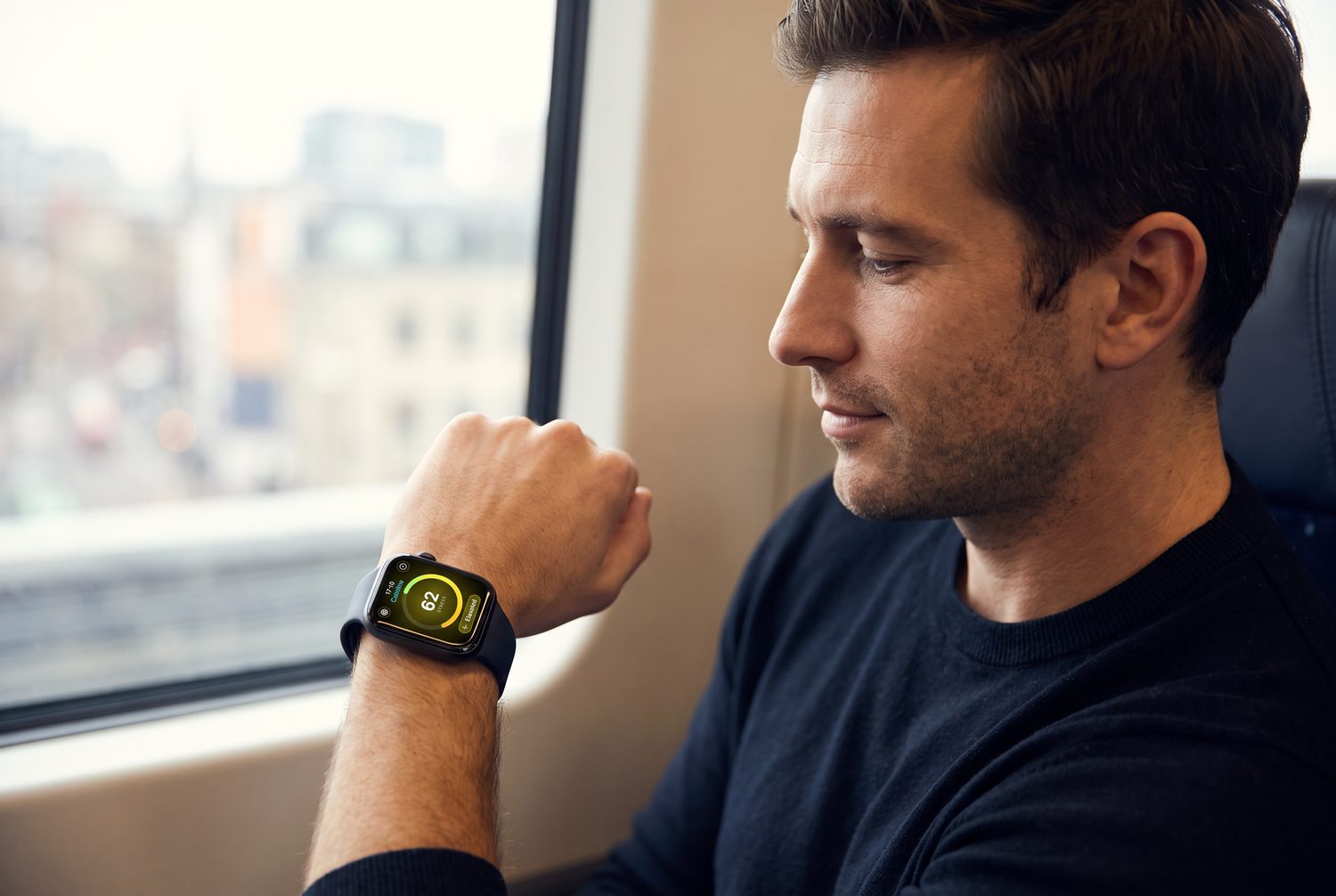A man on a train discreetly glancing at Calmline on his watch